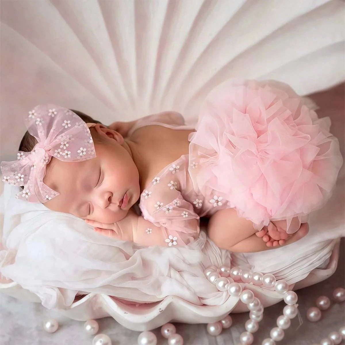 Newborn baby girl in Ylstee circular polka dot romper with matching bow headband for photoshoot